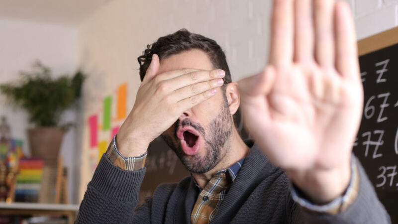 A photo of a teacher covering his eyes.