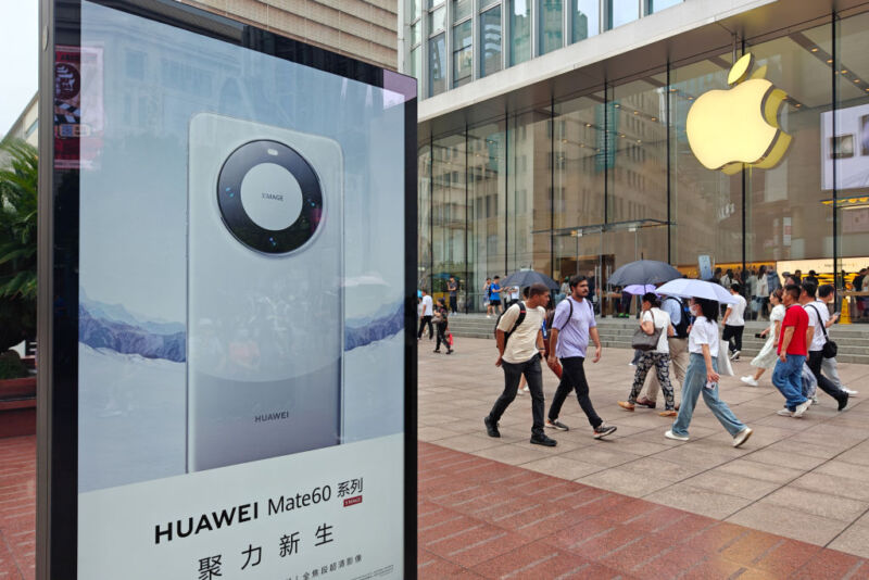 SHANGHAI, CHINA - SEPTEMBER 13, 2023 - A light box advertising Huawei Mate 60 mobile phone is seen in front of the Apple store on Nanjing Road in Shanghai, China, September 13, 2023. 