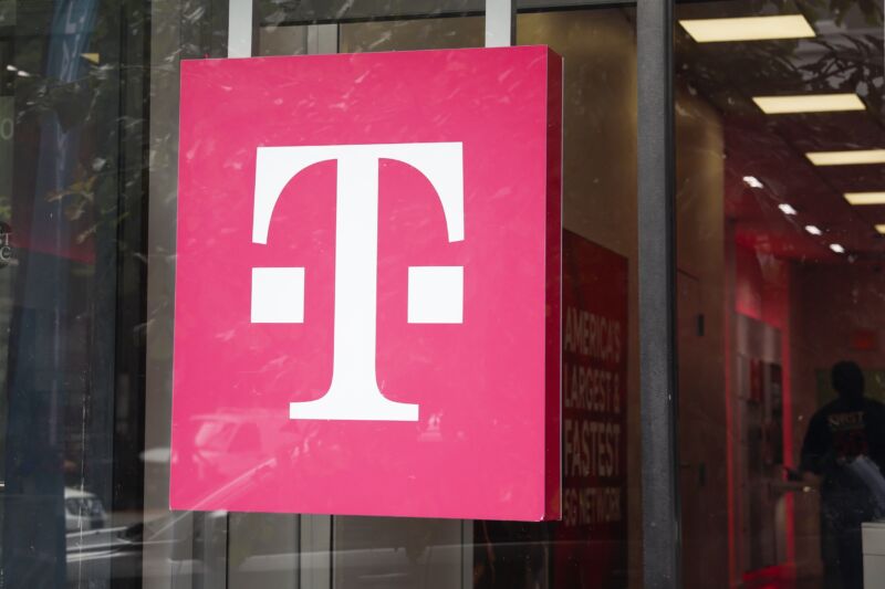 A T-Mobile sign consisting of a large T hangs on a storefront.