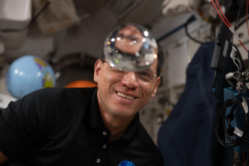 NASA astronaut Frank Rubio observes the behavior of a free-flying water bubble inside the International Space Station's Kibo laboratory module.
