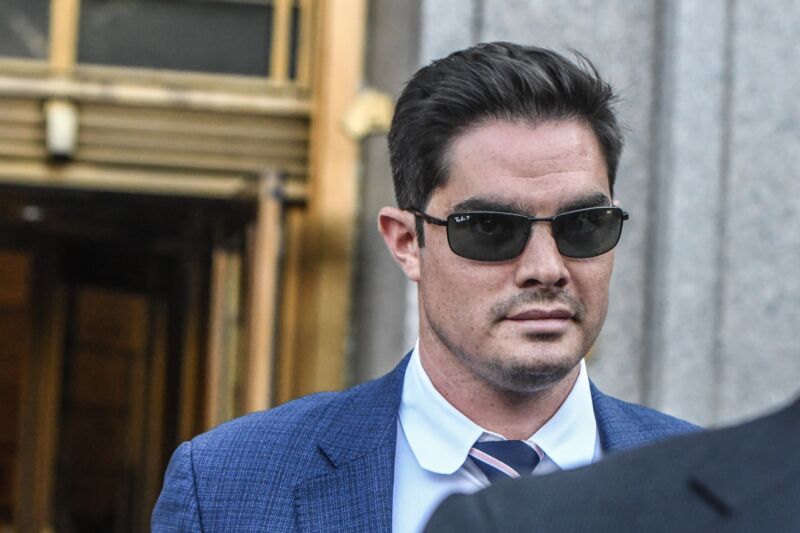 Wearing a suit and sunglasses, former FTX executive Ryan Salame walks out of a courthouse.