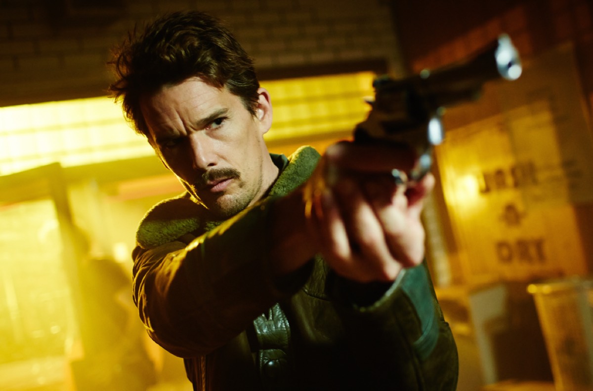 man with mustache pointing a gun