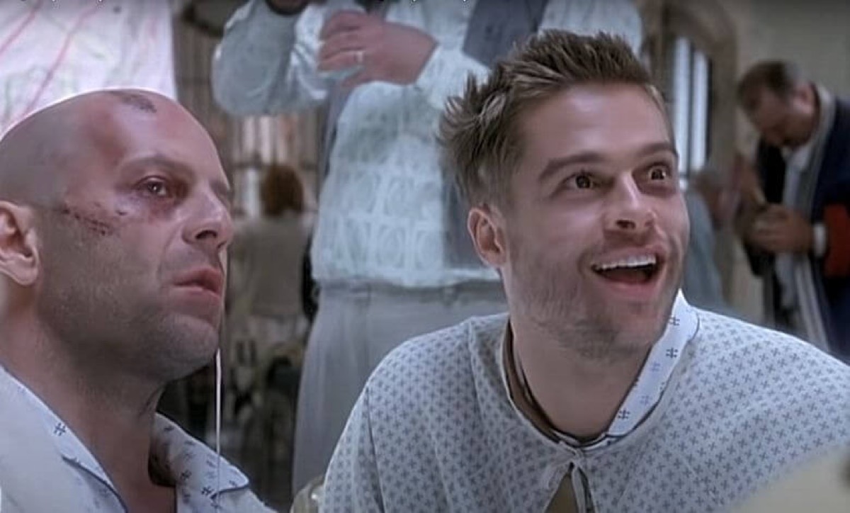 mental hospital patients in gray uniforms, one with a shaved head, the other laughing maniacally