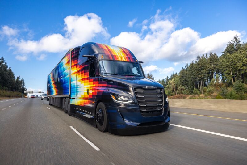 A brightly colored tractor trailer drives on the highway