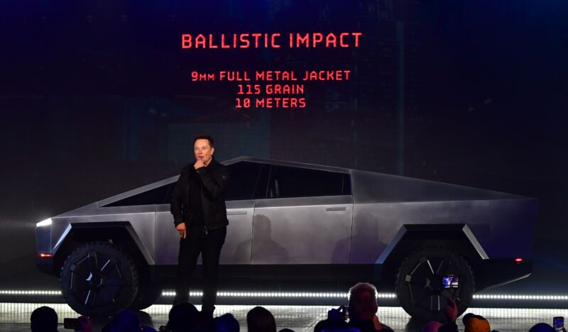 Elon Musk on stage with a prototype Cybertruck. In the background a slide claims the truck is bulletproof