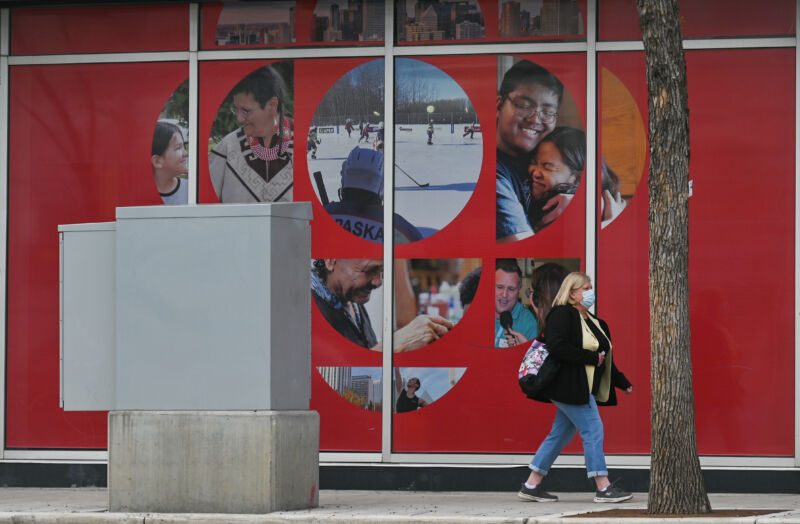 A woman walks past a logo for the Canadian Broadcasting Corp. (CBC) in Edmonton, Alberta, Canada in 2022.