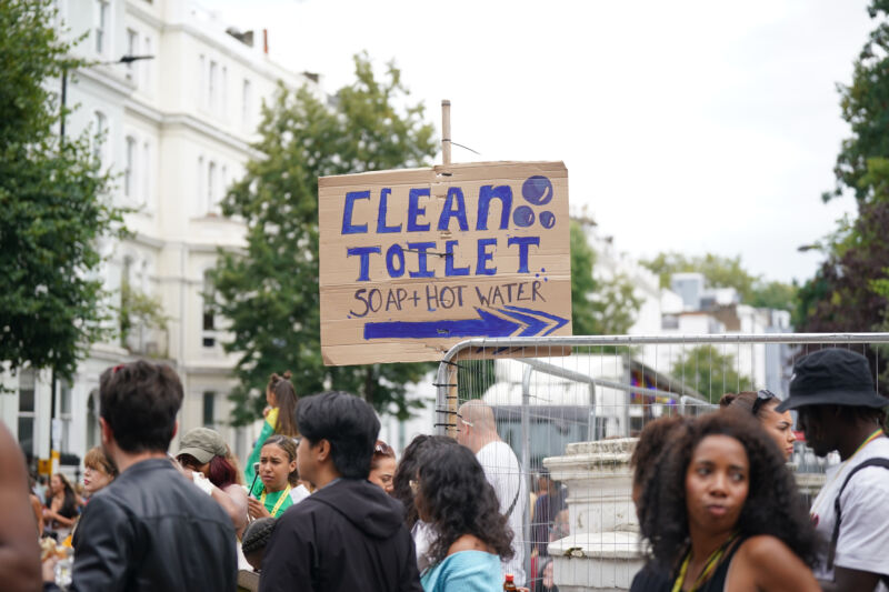 Un semn îndrumă oamenii către toalete în timpul Paradei de Ziua Copilului, parte a sărbătorii Carnavalului de la Notting Hill din vestul Londrei, duminică, 27 august 2023.