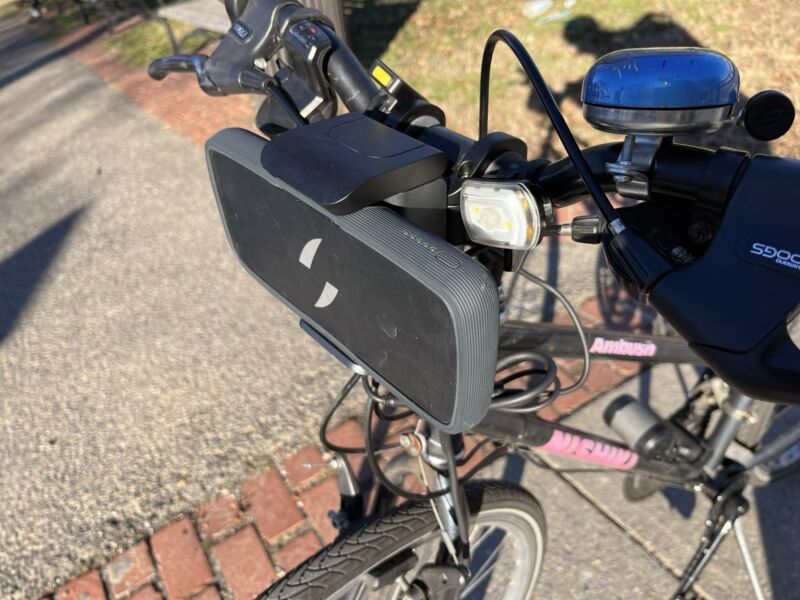 Swytch battery on the handlebar of a gray/pink hybrid bike