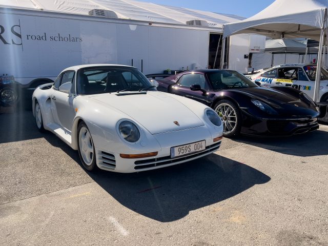 A white Porsche 959 parked next to a metallic purple 918 Spyder