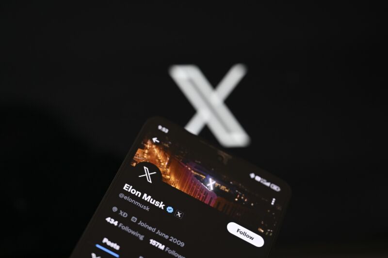 Photo illustration shows Elon Musk's X account displayed on a mobile phone screen in front of a computer screen that displays the X logo.