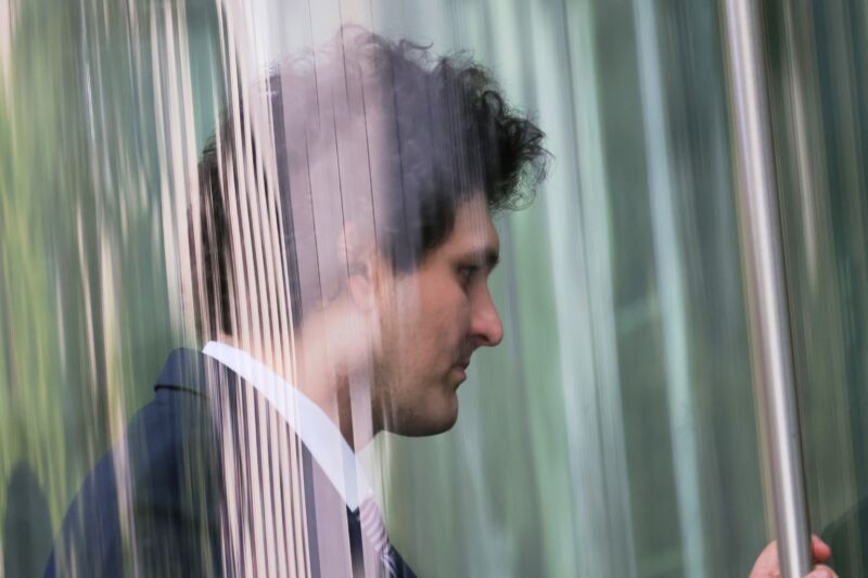 Wearing a suit, former FTX CEO Sam Bankman-Fried pictured from the side as he arrives at court.