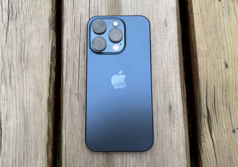 An iPhone sits on a wood table