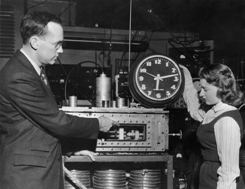 Dr. Charles H. Townes, inventor of the maser, a key component of atomic clocks, illustrates the differences between it and a standard clock. 