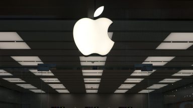 An Apple corporate logo hangs above the front door of a company store