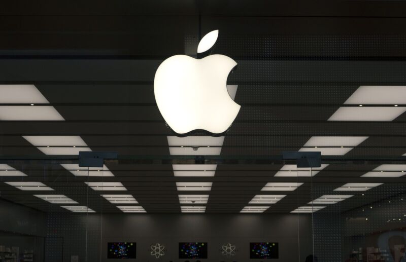 An Apple corporate logo hangs above the front door of a company store