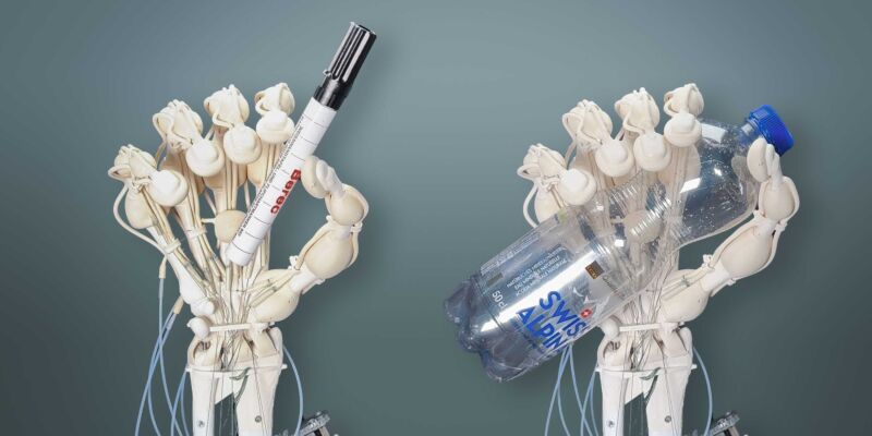 Image of a robotic hand made from light colored plastics grasping both a pen and a bottle in separate images.