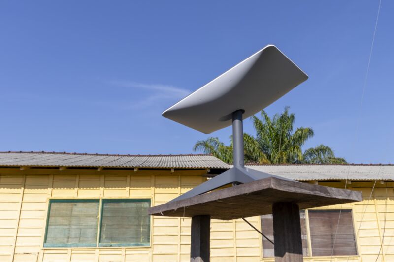 A Starlink broadband satellite dish sitting on a table outside a house.
