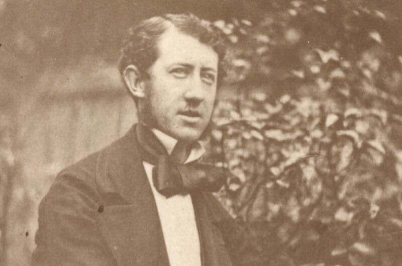 Sepia-toned photograph showing a seated Victorian gentleman wearing a bowtie