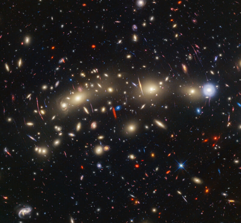 This panchromatic view of galaxy cluster MACS0416 was created by combining infrared observations from the NASA/ESA/CSA James Webb Space Telescope with visible-light data from the NASA/ESA Hubble Space Telescope.