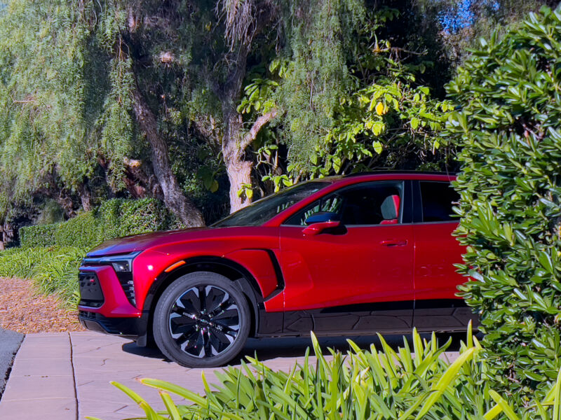 A red Chevrolet Blazer EV pokes out of a driveway