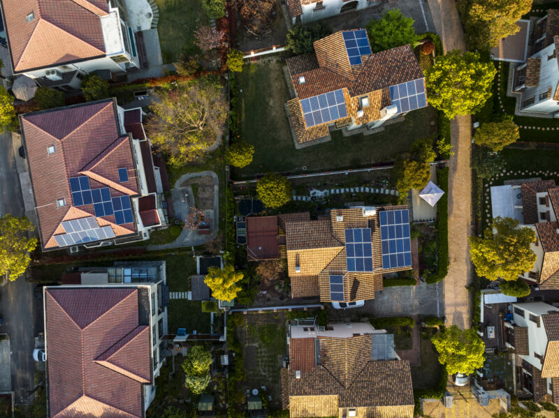 Aerial view of houses with roof-top solar panels.