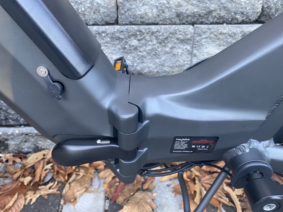 The hinge in the center of the frame that allows the bike to fold. The release will only move if the silver metal slider embedded in it is pushed upward from beneath.