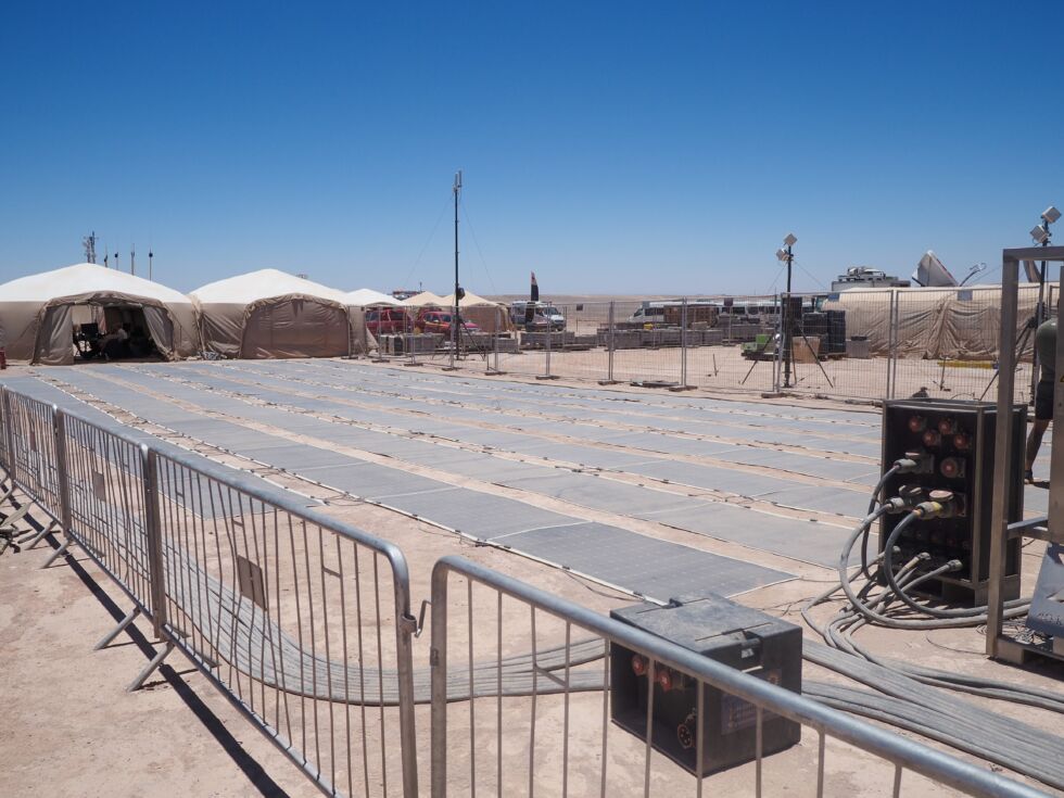 At Extreme E's race site in Atacama Desert, a series of solar panels are set up in the center of the race site.