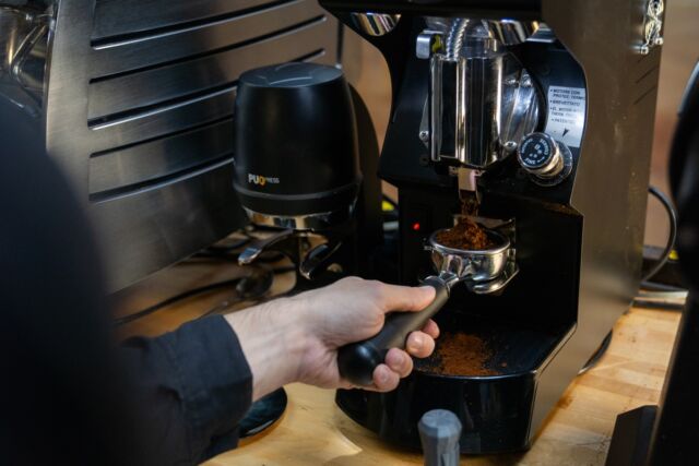 Grinding dry coffee into an espresso portafilter.