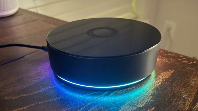 Homey Pro hub sitting on a desk, with a blue-ish rainbow glow on bottom