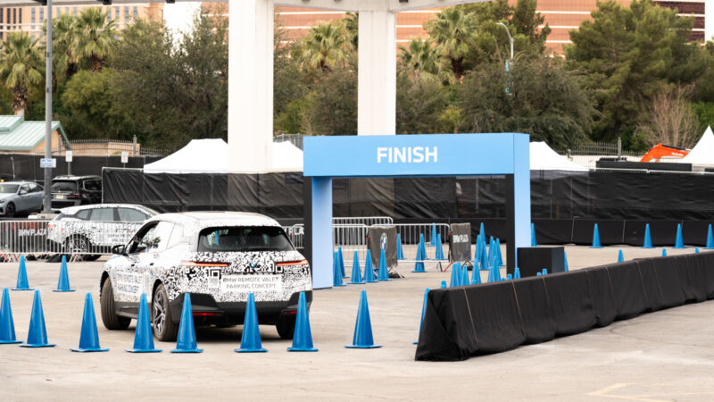 A BMW iX is remotely driven around a CES parking lot