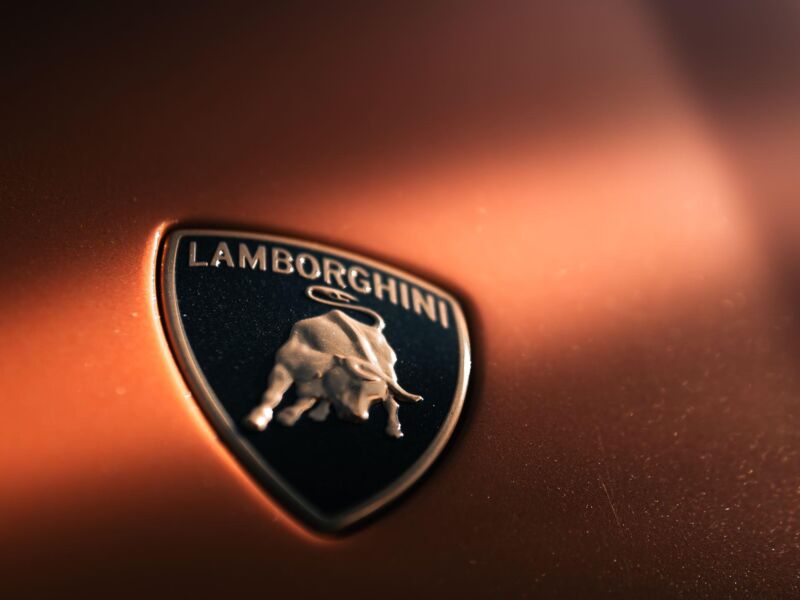 A Lamborghini badge on an orange car hood