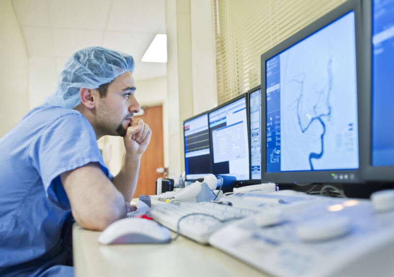 Un técnico médico observa una exploración en un monitor de computadora.