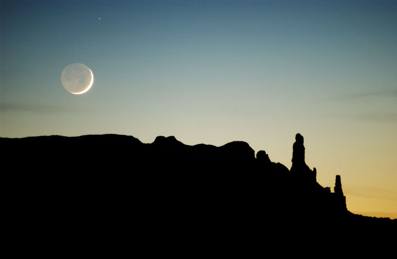 The Moon sets over sandstone formations on the Navajo Nation.