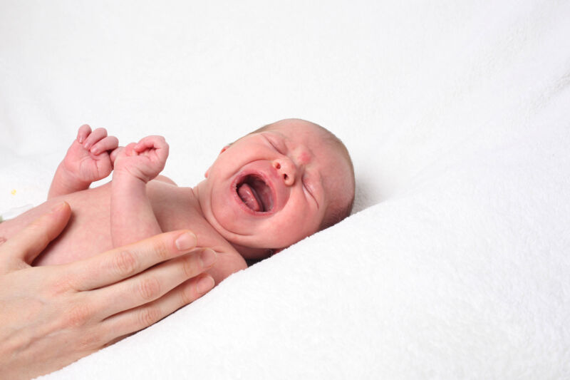 A studio portrait of a crying baby. 