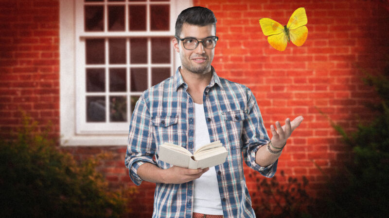 Man holding a book gesturing at a butterfly