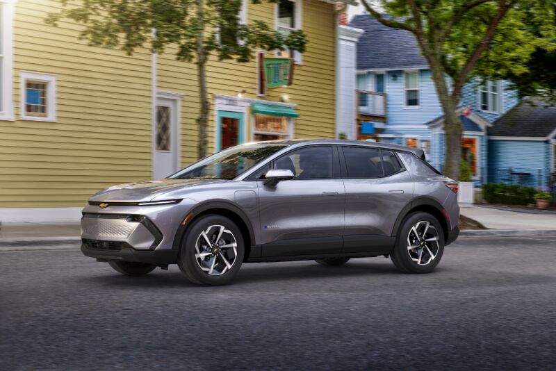 Driver’s side view of 2024 Chevrolet Equinox EV 1LT in Galaxy Gray Metallic driving down the road.