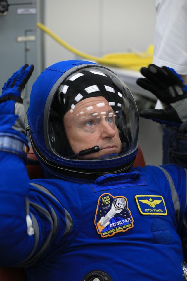 رائد فضاء ناسا بوتش ويلمور، قائد أول رحلة لطاقم ستارلاينر، يحاول ارتداء بدلة فضاء من طراز بوينج أثناء اختبار التحقق من صحة الطاقم في مركز كينيدي للفضاء التابع لناسا في عام 2022.