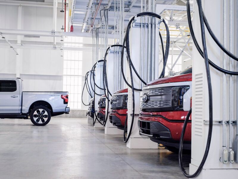 A row of Ford F-150 Lightnings charging at the factory