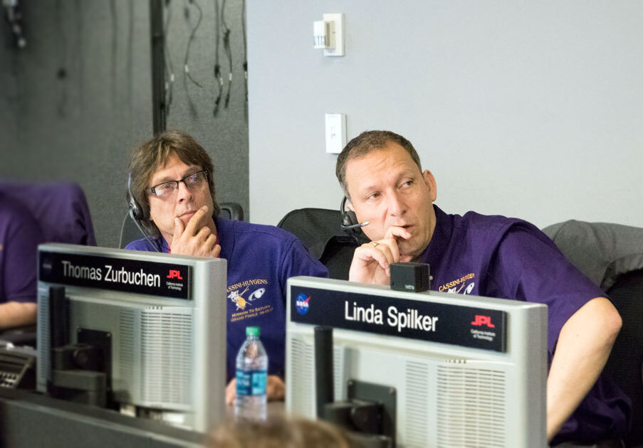 Three_men_in_mission_control_looking_at_