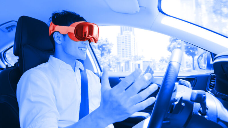 A mock-up of a person in a car wearing the Apple Vision Pro headset.