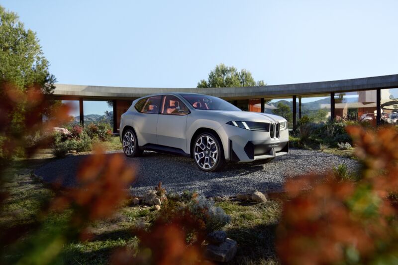 Un concepto BMW Vision Neue Klasse X en el patio de una casa moderna