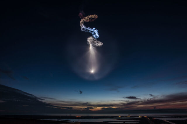 The exhaust plume of a Falcon 9 rocket is seen illuminated by sunlight following a launch before sunrise in 2018.