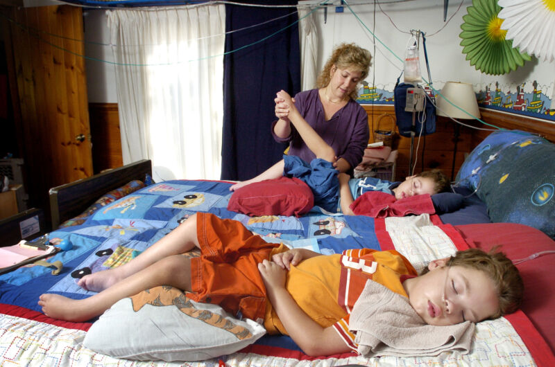 Una madre con sus hijos gemelos de 6 años que padecen leucodistrofia metacromática, una enfermedad genética que les impide moverse.  Foto tomada el 3 de septiembre de 2004.