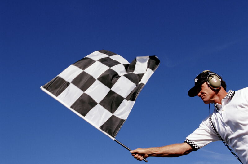 a man waves a checkered flag