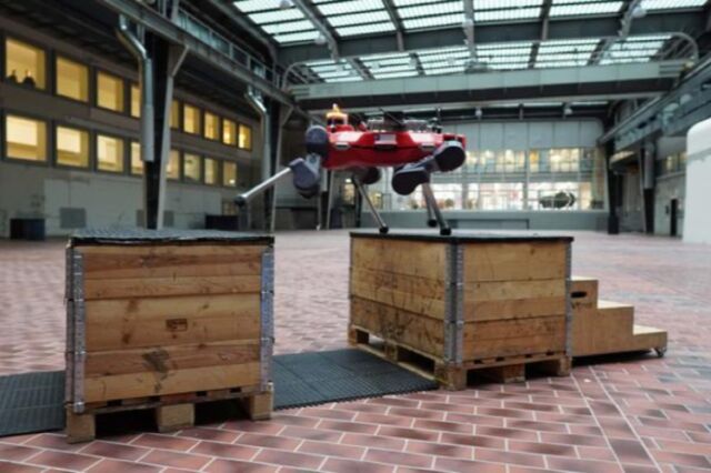 The quadrupedal robot ANYmal practices parkour in a hall at ETH Zürich.