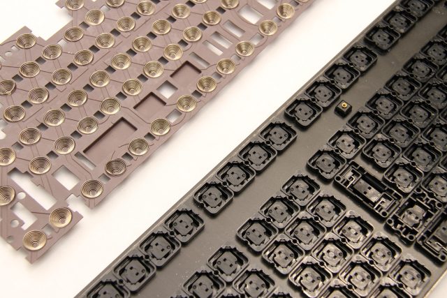 ii. Top-left: The underside of a Topre keyboard’s rubber dome sheet with the conical springs visible. Bottom-right: A Topre keyboard’s mounting plate.
