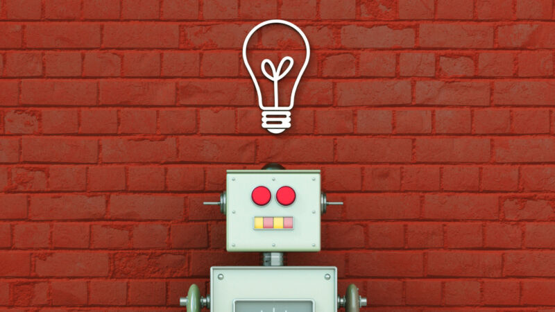 A 3D rendering of a toy robot with a light bulb over its head in front of a brick wall.