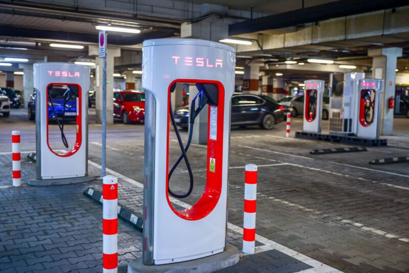 Four Tesla charging stations inside a parking garage.