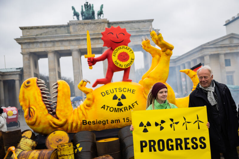 Jürgen Trittin, poslanec nemeckého Bundestagu a bývalý minister životného prostredia, stojí vedľa aktivistu počas akcie environmentálnej organizácie Greenpeace pred Brandenburskou bránou v apríli 2023. Táto akcia má osláviť odstavenie posledných troch nemeckých jadrových elektrární rastliny.
