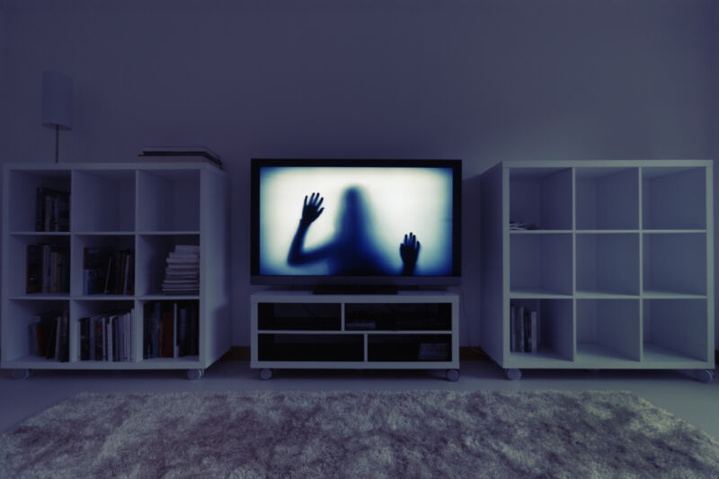 Siluetă a unei fete prinse în interiorul unui televizor în interiorul unui centru de divertisment